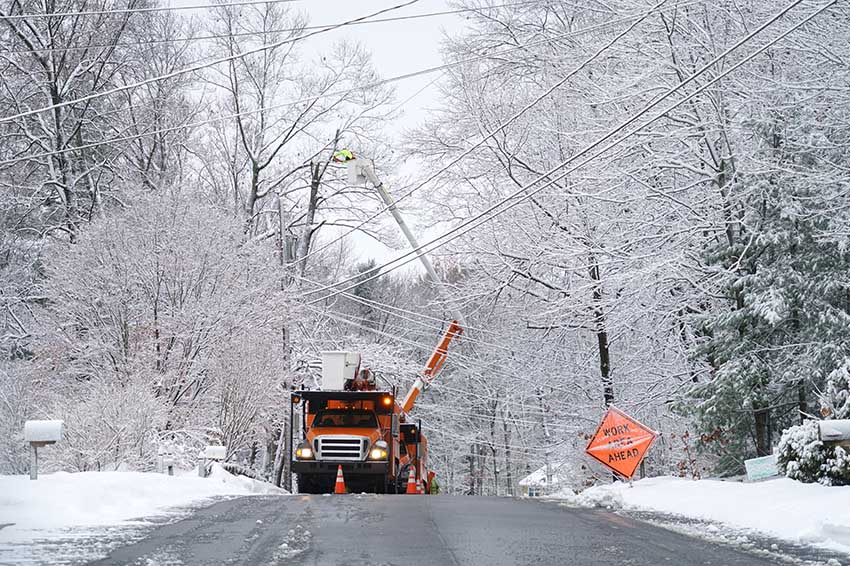 Worker repairing electrical line after winter snow storm