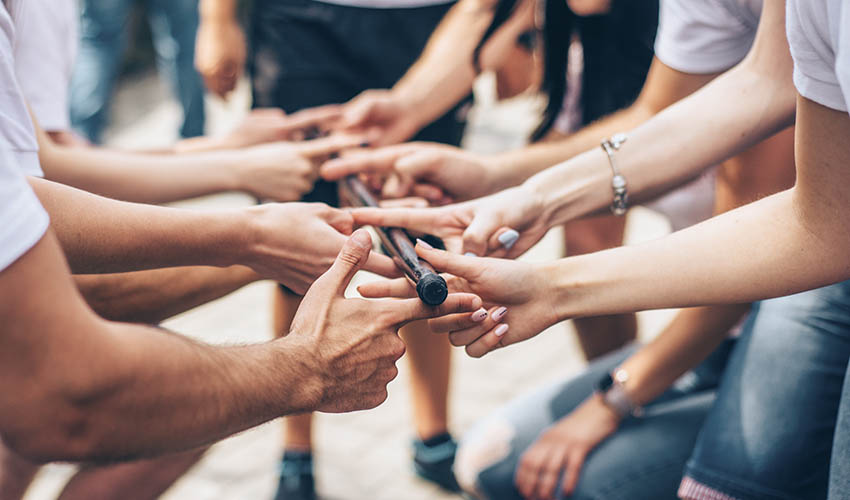 A team-building activity where participants have to support a heavy stick with only one finger each