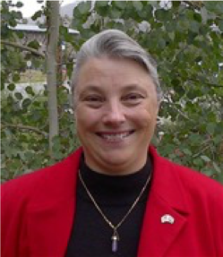 Headshot of Flo Raitano from the shoulders up smiling in business casual attire