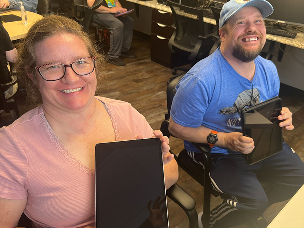 Program participants smiling with iPads