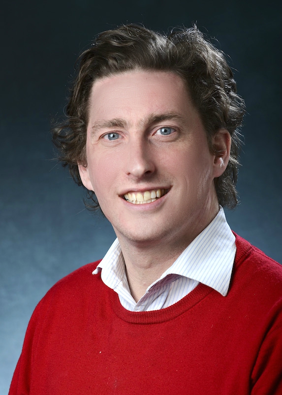 headshot of Correll smiling in business casual dress shirt