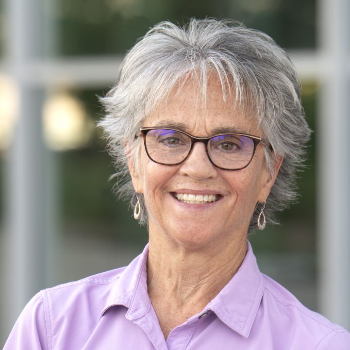 Headshot of Kelly Waugh from shoulders up smiling in business attire