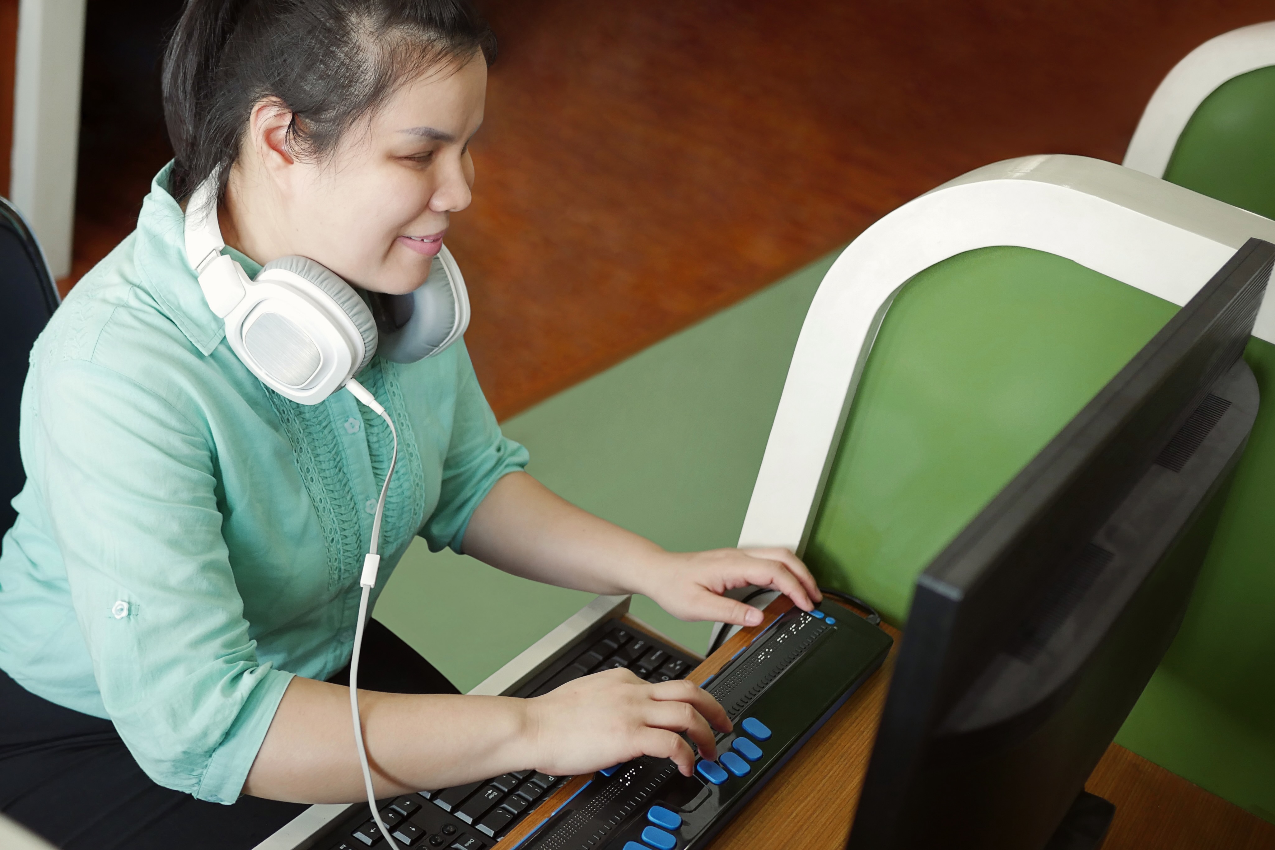 A woman using assistive technology at a computer