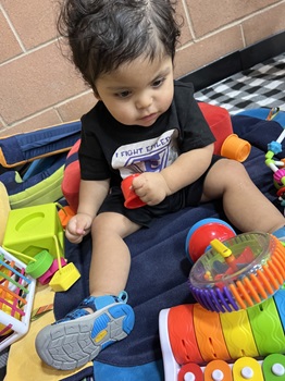 young boy using assistive technology to sit upright and play with toys