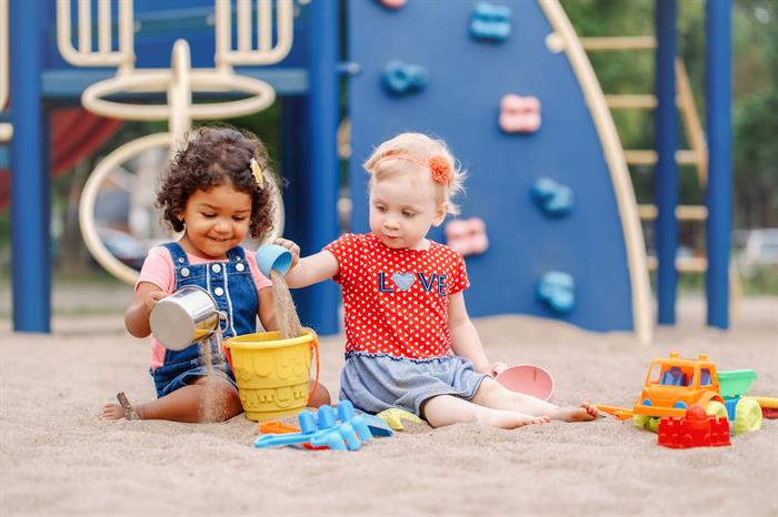 Little girls playing with sand toys outside